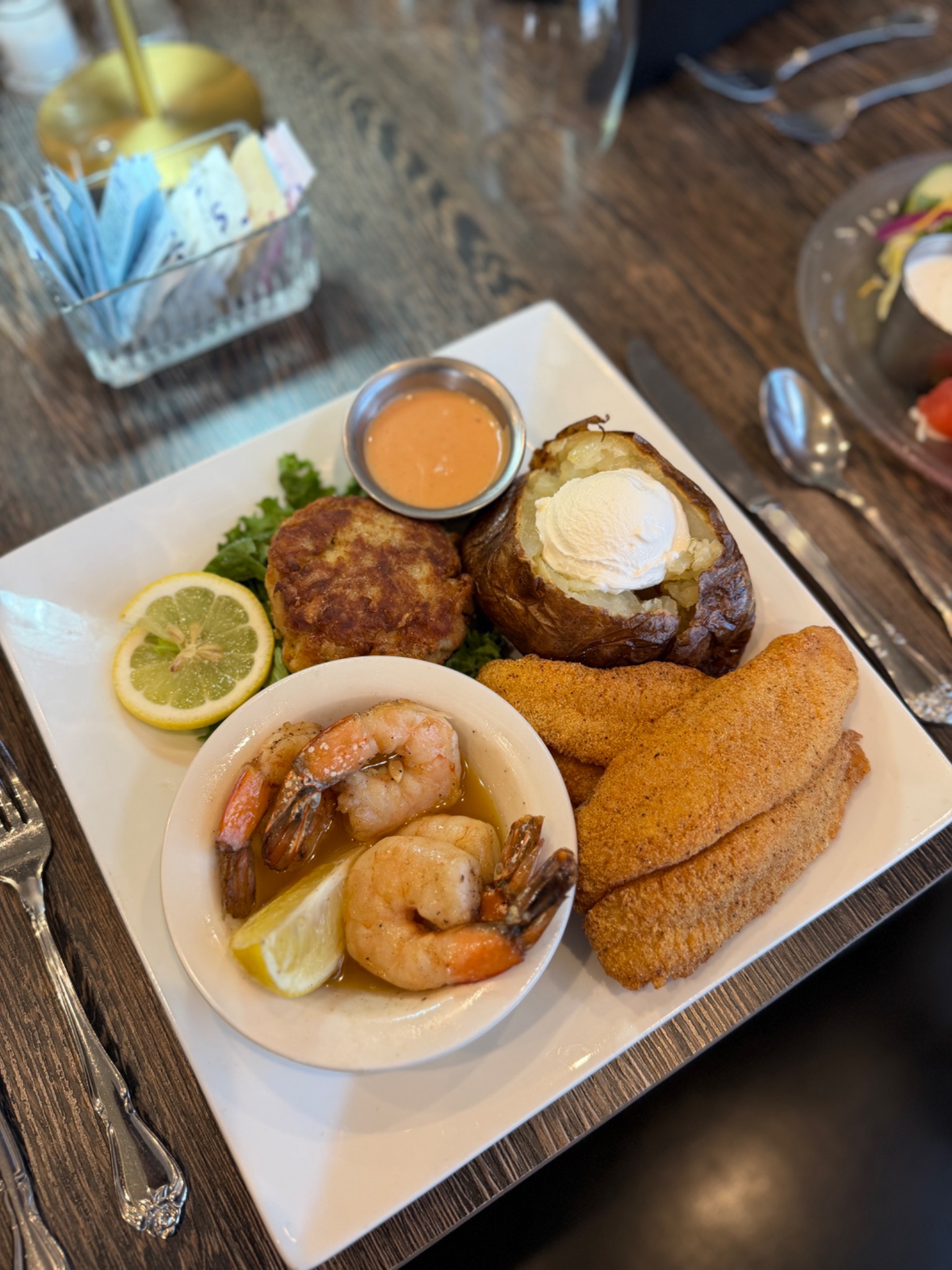 The Fairways Seafood Trio with shrimp scampi, fried catfish, crab cake, and a baked potato